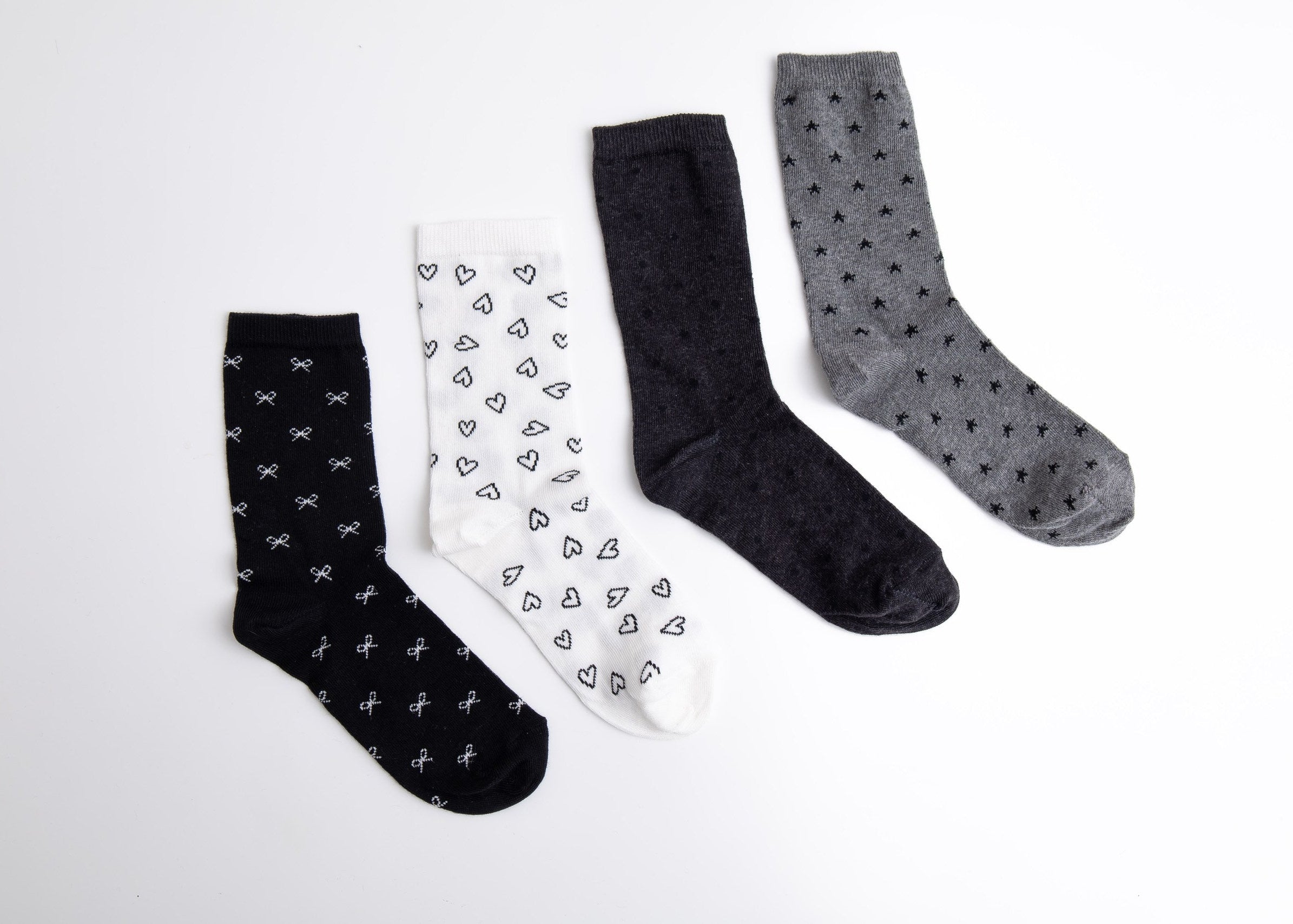 Four pairs of socks in black, white, and gray with different patterns on a light gray background.

