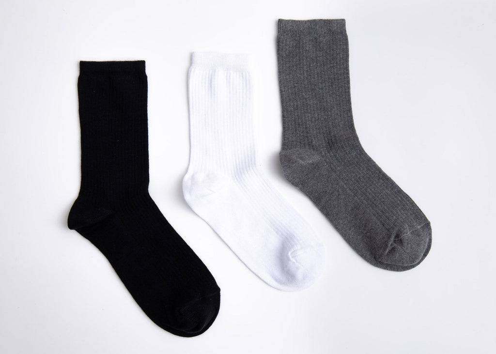 Three socks in black, white, and gray on a light gray background

