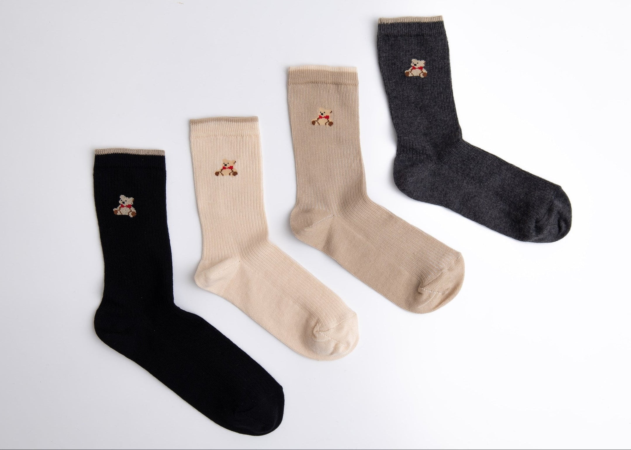 Four pairs of socks in black, beige, and gray on a white background

