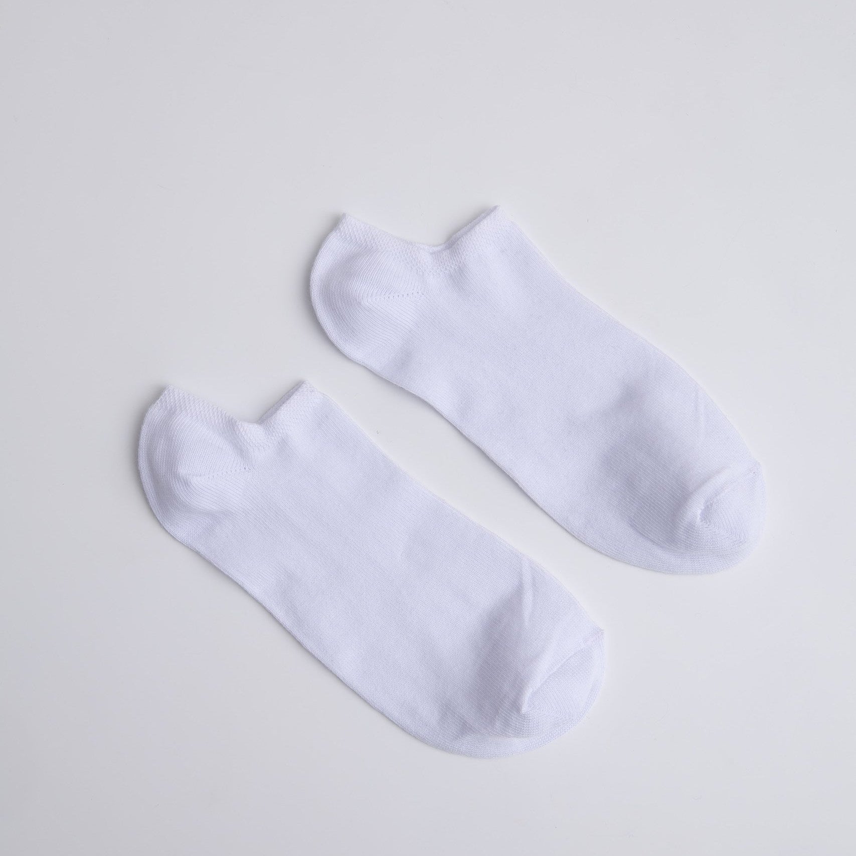 Two white ankle socks on a light gray background

