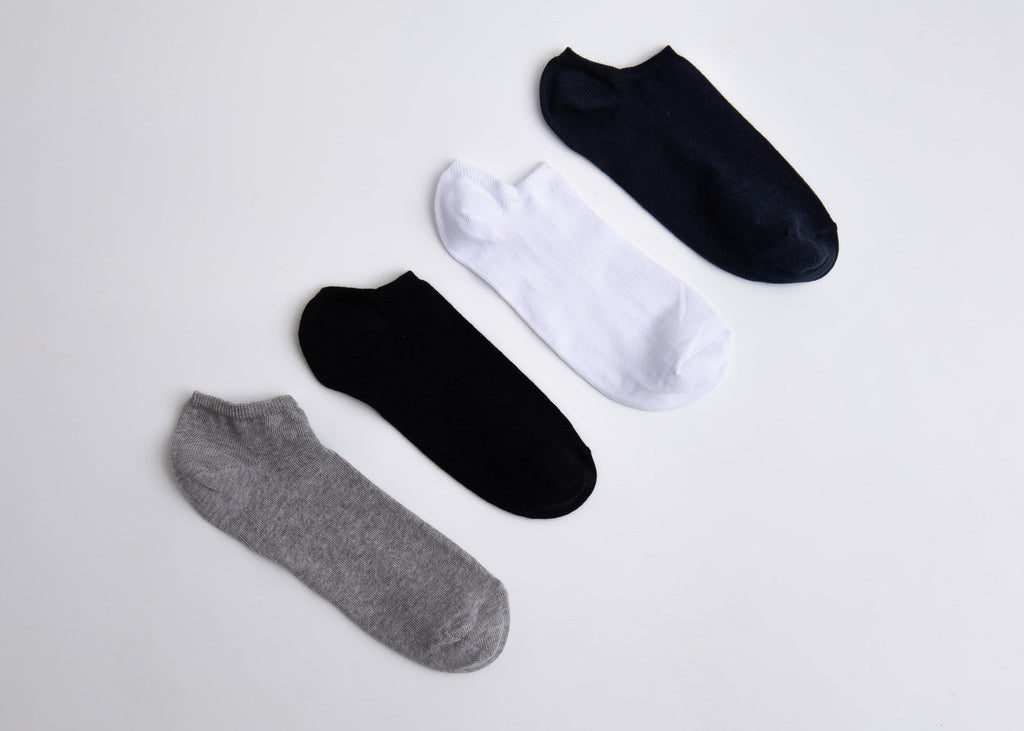 Set of five different colored ankle socks on a light gray background

