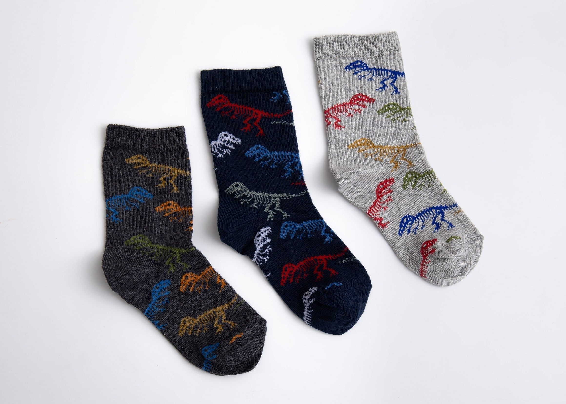 Three pairs of socks with dinosaur patterns on a white background


