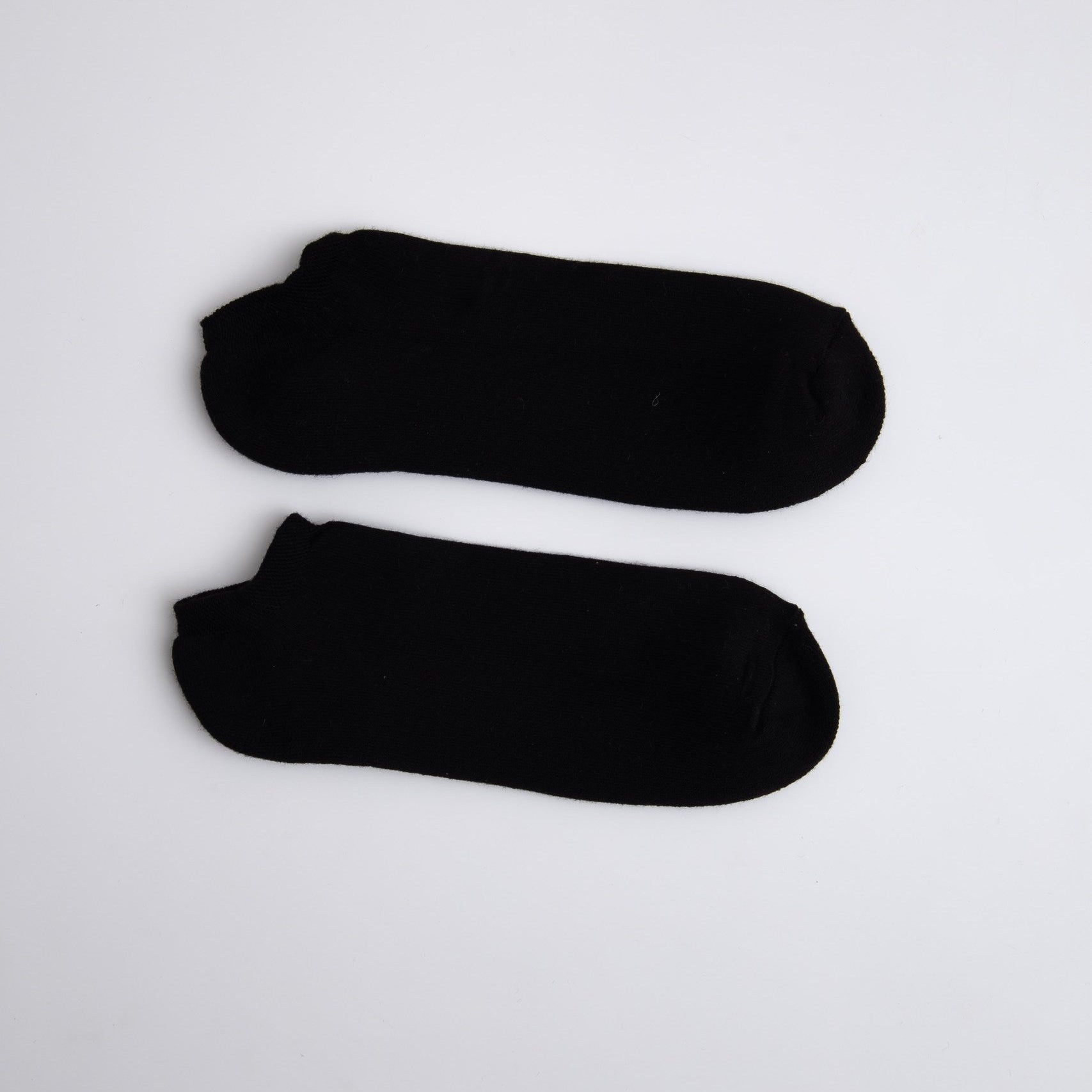 Two black ankle socks on a white background

