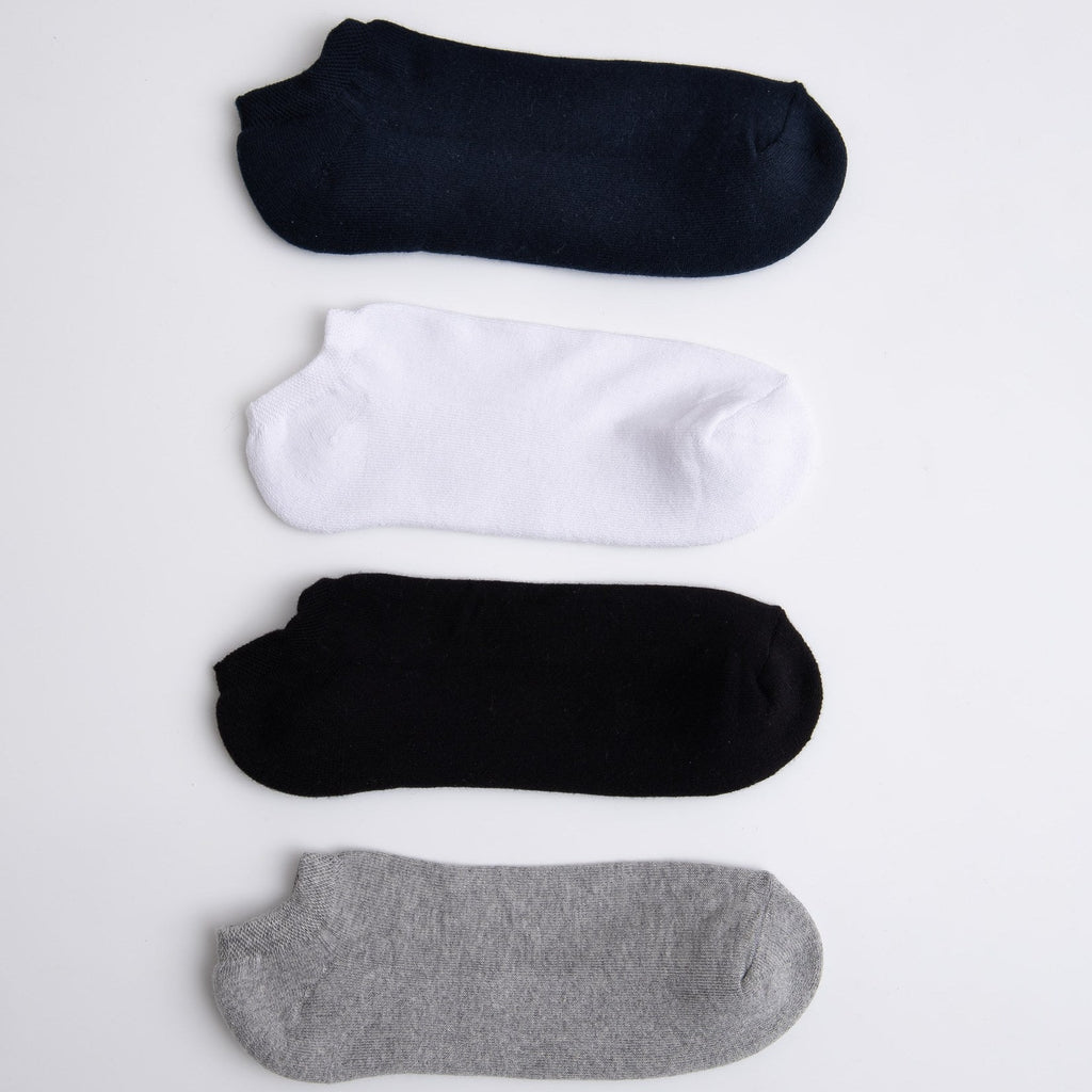 Four pairs of socks in black, white, and gray on a light gray background

