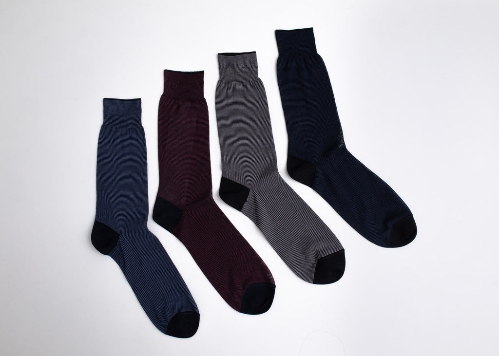 Four pairs of socks in navy, burgundy, gray, and black on a white background

