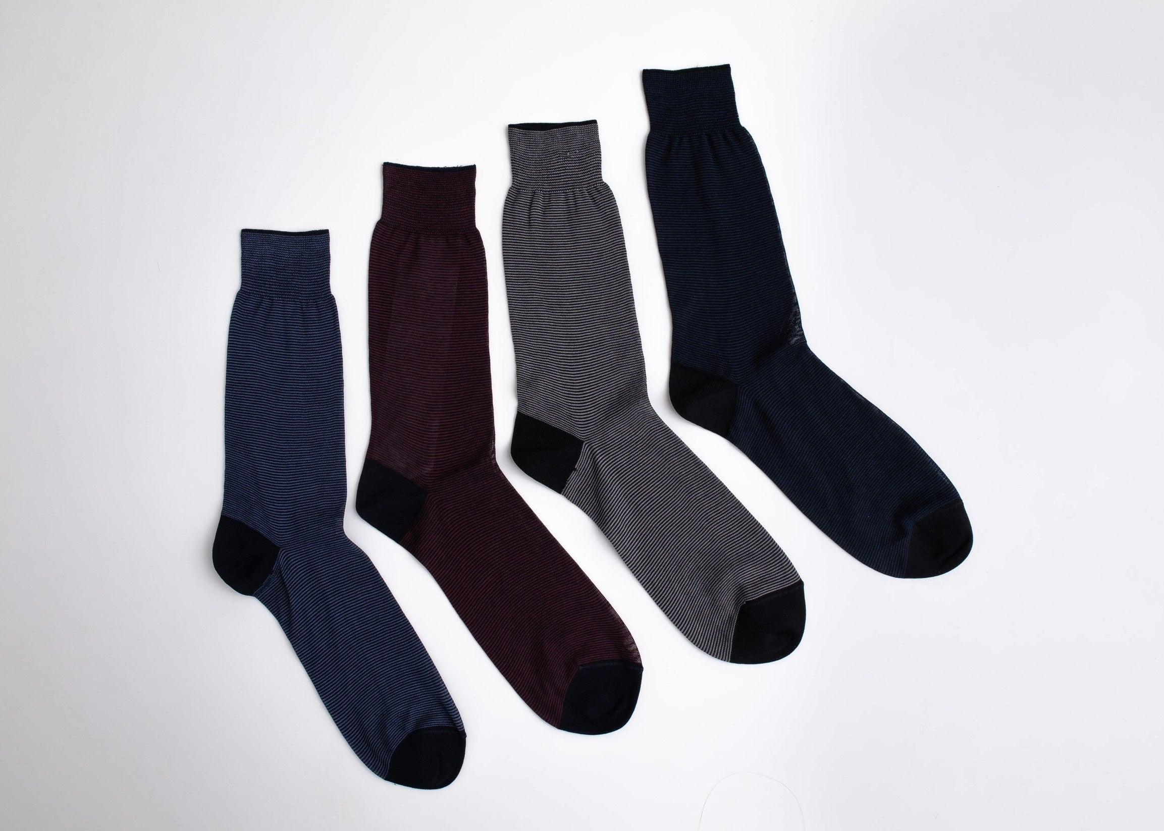 Four pairs of socks in navy, burgundy, gray, and black on a white background

